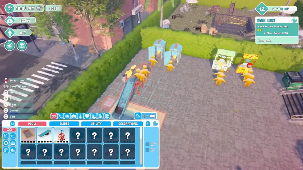 Overhead build mode on PS5 with a slide already in the park picked up and outlined, and a control list reading Select Item, Camera Zoom, Move, Snap, Place, Cancel and Quit