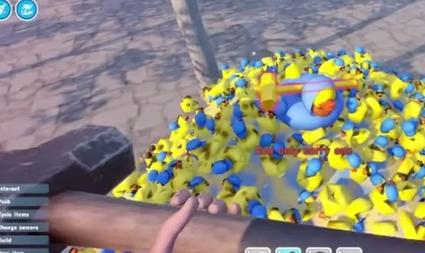 A heap of yellow and blue rubber ducks in the city outside the park, with a golden sledgehammer and a large blue duck on top